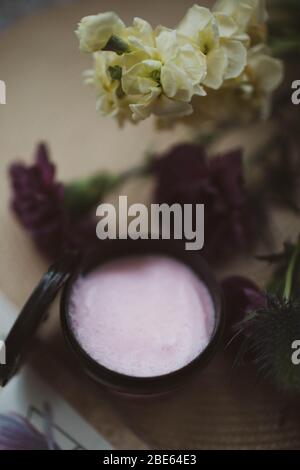 Pink body scrub in a small black plastic jar.Pink body scrub in a small black plastic jar. Stock Photo
