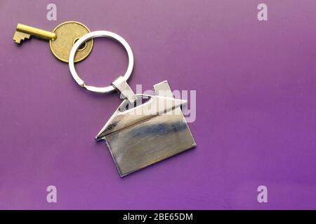 House keys with house shaped key chain on color background Stock Photo