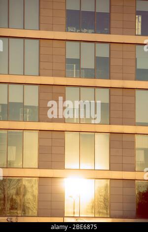 A fragment of the façade plane with windows reflecting the shining morning sun. Stock Photo