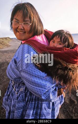 Inuit woman with her baby in traditional Amauti dress in North Americas ...