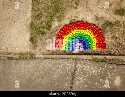 rainbow made out of colored stone on the floor of someone house to make people smile while they’re walking by, and also offer a message of hope. Stock Photo