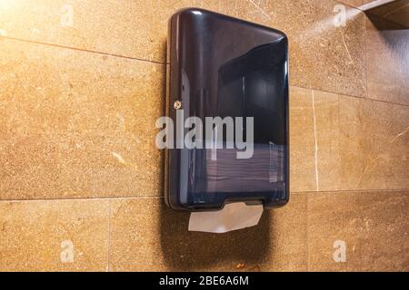 Paper towel black dispenser on the wall in a public toilet Stock Photo