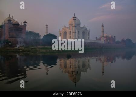 View of Taj Mahal with early morning fog reflected in Yamuna River, Agra, Uttar Pradesh, India. Taj Mahal was designated as a UNESCO World Heritage Si Stock Photo