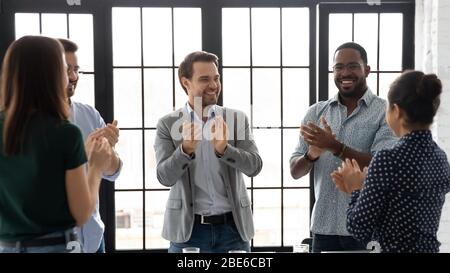 Excited businesspeople applaud celebrating business success at meeting Stock Photo