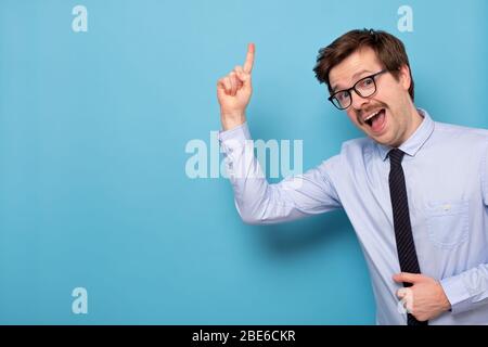 Satisfied young man in glasses showing index finger up, giving advice or recommendation Stock Photo