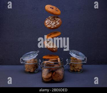 Cookies with almond crumbs and cookies with lingonberries. Round homemade cookies flies in a jar. Levitating cookies. Biscuit sweet pastries homemade Stock Photo