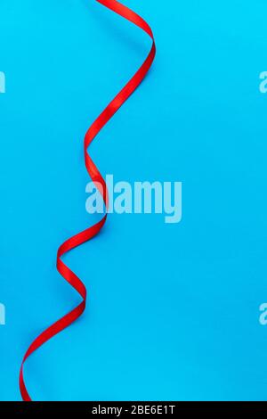 Wavy red ribbon on a blue background vertical. Copyspace. Copy space. Postcard. Background for text. Wallpaper for a computer. Stock Photo