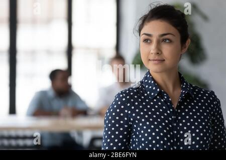 Female indian employee look in distance thinking of career opportunities Stock Photo