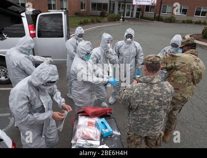 Massachusetts National Guard members don personal protective equipment before COVID-19 testing on residents at the Alliance at West Acres nursing home April 10, 2020 in Brockton, Massachusetts. Stock Photo
