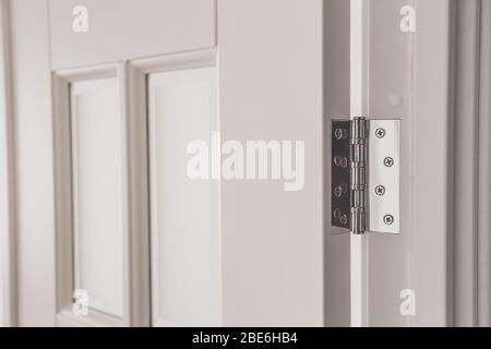 stainless door mortised hinge on a white door. Stock Photo