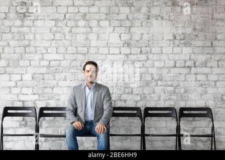 Smiling Caucasian male applicant wait for office interview Stock Photo