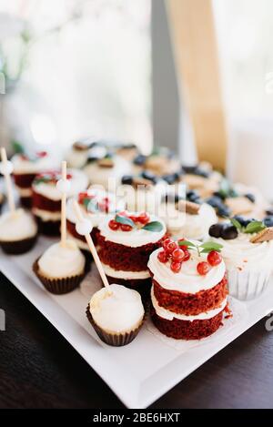 Group of many small tasty sweet snacks, tiny cakes. Lots of mini sugary cupcakes Stock Photo