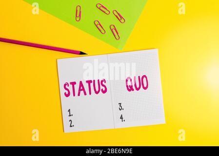 Text sign showing Status Quo. Business photo showcasing existing state of affairs regarding social or political issues Blank paper sheet pencil clips Stock Photo