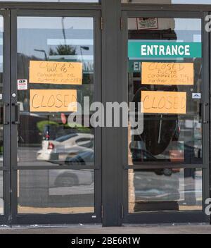 Sign on store door 'closed due to coronavirus.' Stock Photo