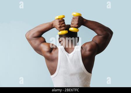 Black man working hard on his fitness in self isolation over blue Stock Photo