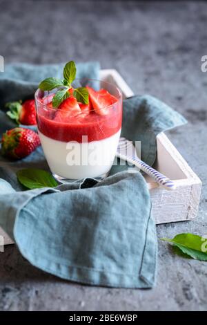 Traditional Panna cotta with strawberry sauce topping, served in a glass jar Stock Photo