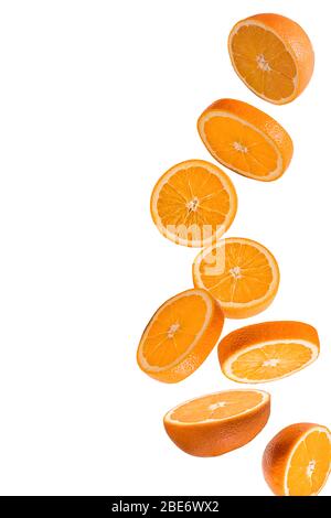 Flying fruits. Falling sliced orange fruit isolated on white background to use in design. Stock Photo