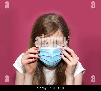 Young woman putting surgical mask on her face without using glove Stock Photo