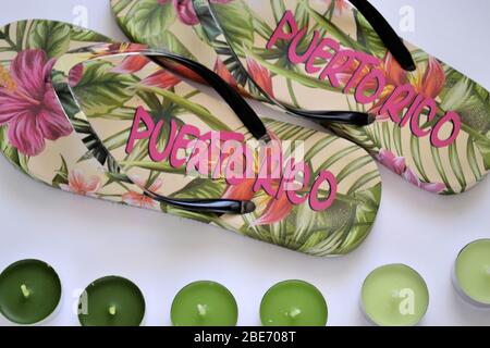 Beach flip-flops from Puerto Rico with green tea light candles, flat lay on the white background Stock Photo