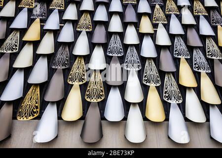 Metallic laser-cut feather design public artwork on the outside wall of a  multi-storey car park in the Justice Precinct of Christchurch, New Zealand. Stock Photo