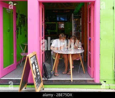 Picton, Marlborough Sounds/New Zealand - February 1, 2020: Tourists eating ice creams engrossed with their cellphones in an ice cream shop in Picton, Stock Photo