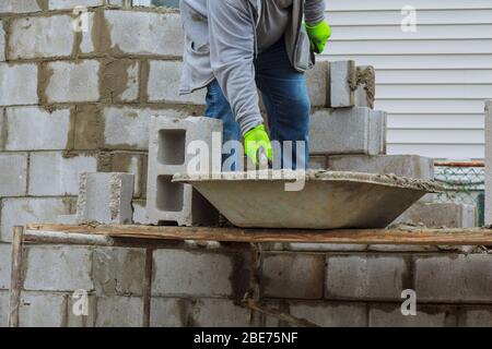 Bricklayers new house wall on foundation hands with in masonry bricklaying Stock Photo