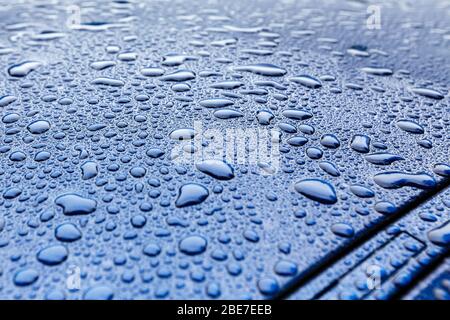 Raindrops close-up on a blue car body with Hydrophobic Effect. Stock Photo