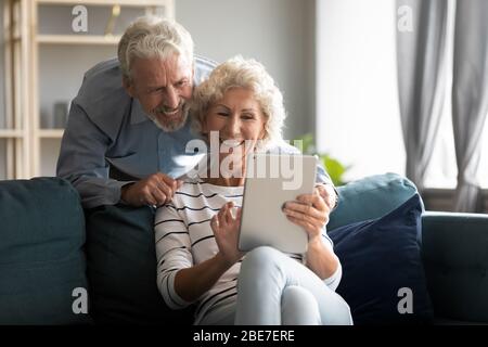 Happy older couple using computer tablet together at home Stock Photo