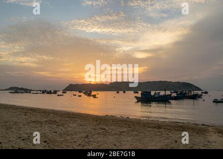 Boats moored off the Beach at Sunrise Stock Photo