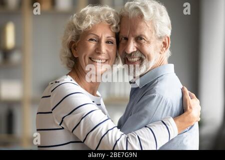 Head shot portrait happy older couple hugging, looking at camera Stock Photo
