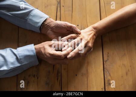 Older man putting engagement ring on woman finger close up Stock Photo