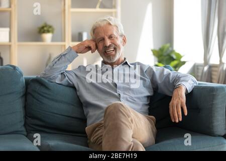 Portrait smiling mature man sitting on couch at home Stock Photo
