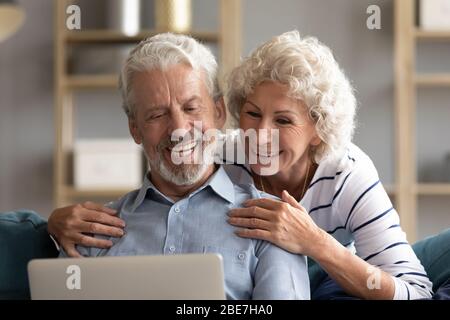 Smiling older couple looking at laptop screen together close up Stock Photo