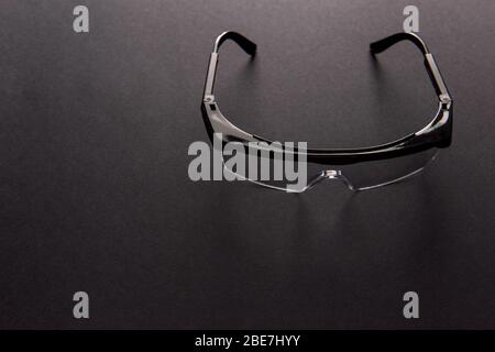 Transparent safety goggles on dark gray background Stock Photo