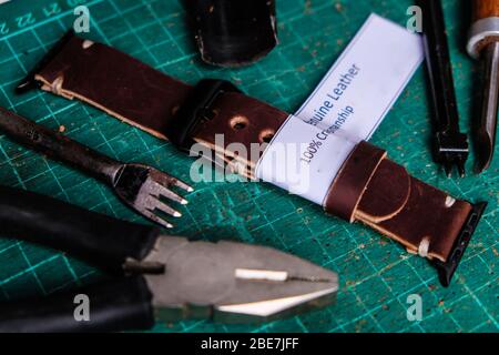 Leather watch strap craftsmanship working with white label on green board Stock Photo