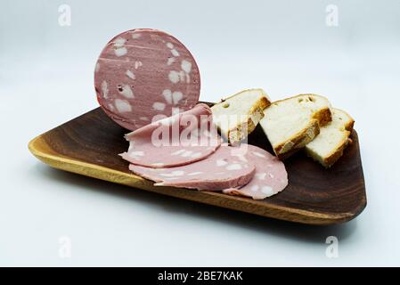 Italian Mortadella bolognese with slices of bread. Pork salami Mortadella isolated on white Stock Photo