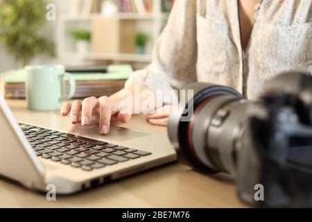 Close up of photographer woman hands connecting camera and laptop transfering files on a desk at home Stock Photo