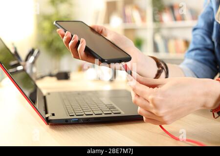 Close up of student hands plugging battery charger to smart phone at home Stock Photo