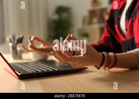 Close up of student girl hands stress relieving doing yoga pose at night at home