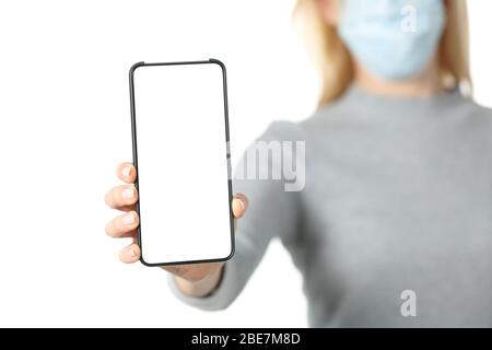 Close up of woman hand with protective mask showing blank phone screen isolated on white background Stock Photo