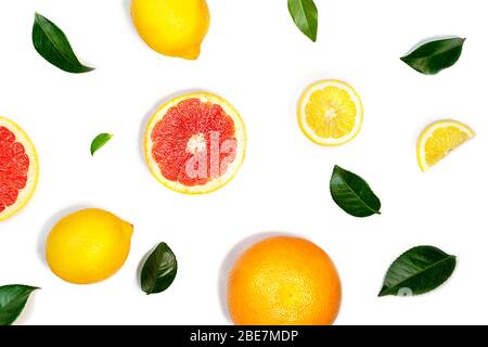 Creative layout made of lemon, grapefruit and green leaves on white background. Flat lay, close up. Tropical food concept. Stock Photo