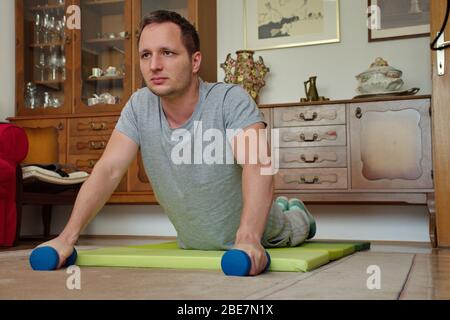 Portrait of young man doing plank exercise at home Stock Photo
