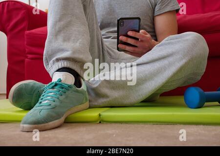 Midsection of young man using smartphone during workout at home Stock Photo