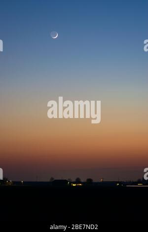 Colorful twilight sky with small sickle moon Stock Photo