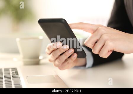 Cloe up of executive woman hands checking smart phone sitting on a desk at office Stock Photo