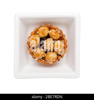 Macadamia nut tart in a square bowl isolated on white background; Stock Photo