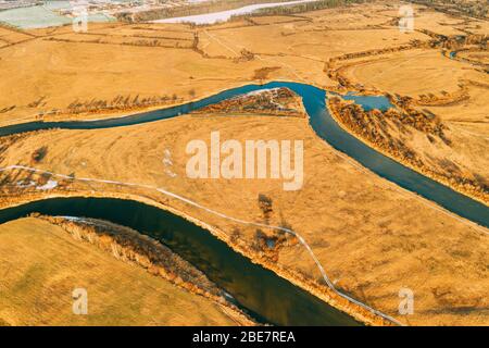 Belarus. Aerial View Of Dry Grass And Partly Frozen Curved River Landscape In Late Autumn Day. High Attitude View. Marsh Bog. Drone View. Bird's Eye V Stock Photo