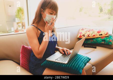 Asian woman wearing  medical mask works from home during quarantine. Stock Photo