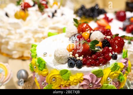 Cakes and pastries in a shop window. Pastry shop with variety of donuts, Creme brulee, cakes with fruits and berries Stock Photo