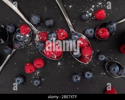 Looking down on a flat lat of raspberries and blueberries on a slate background Stock Photo